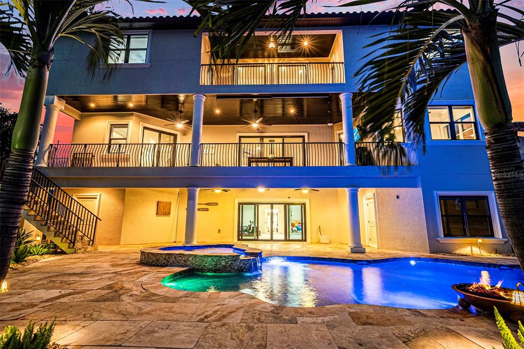 A multi-story house exterior features a swimming pool, hot tub, and two levels of balconies — 231 MIDWAY ISLAND, CLEARWATER BEACH, FL
