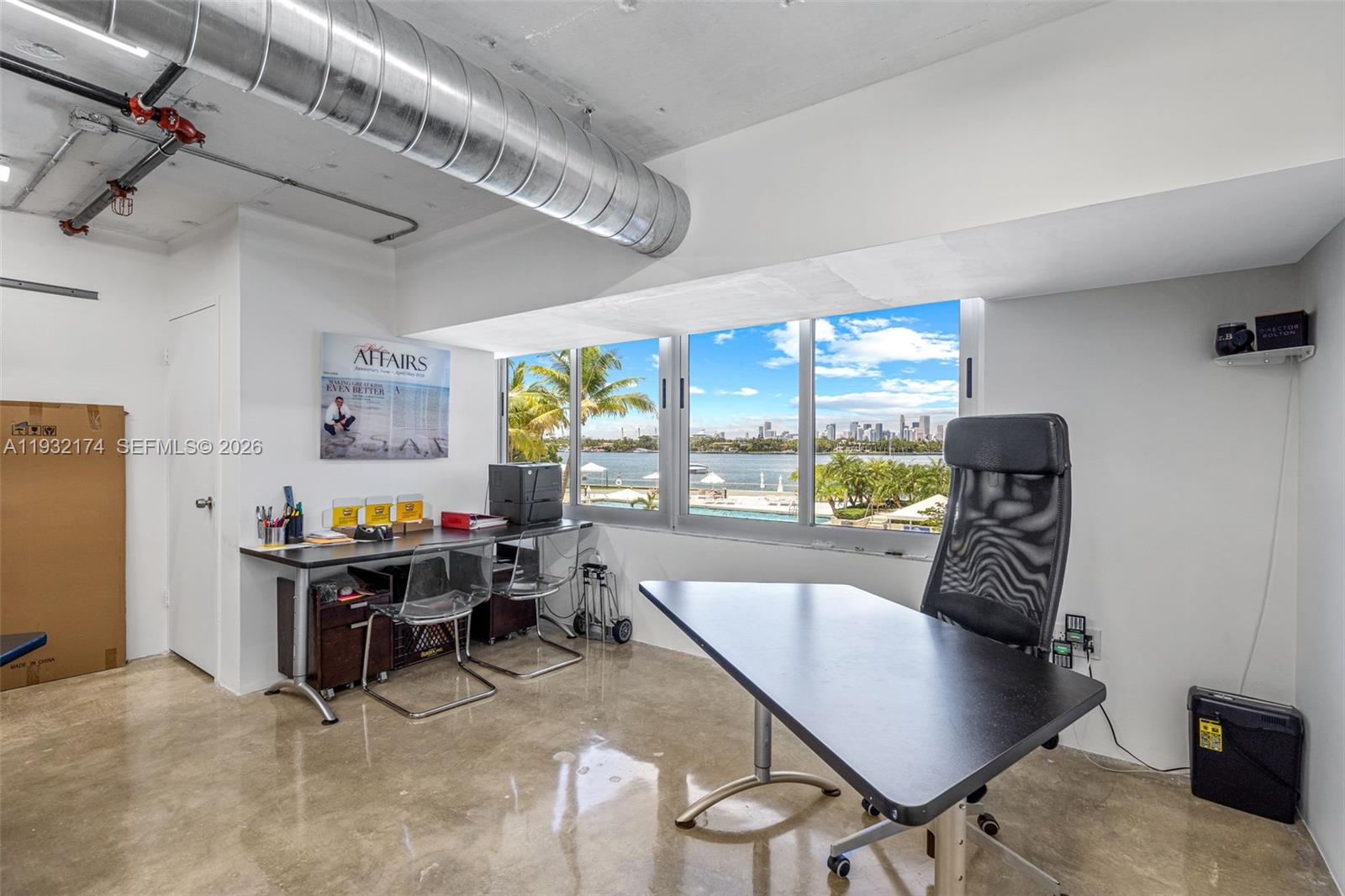 An office with a concrete floor, exposed ductwork, and a view of a city skyline — 1200 West Ave # 7, Miami Beach FL 33139, MIAMI BEACH, FL