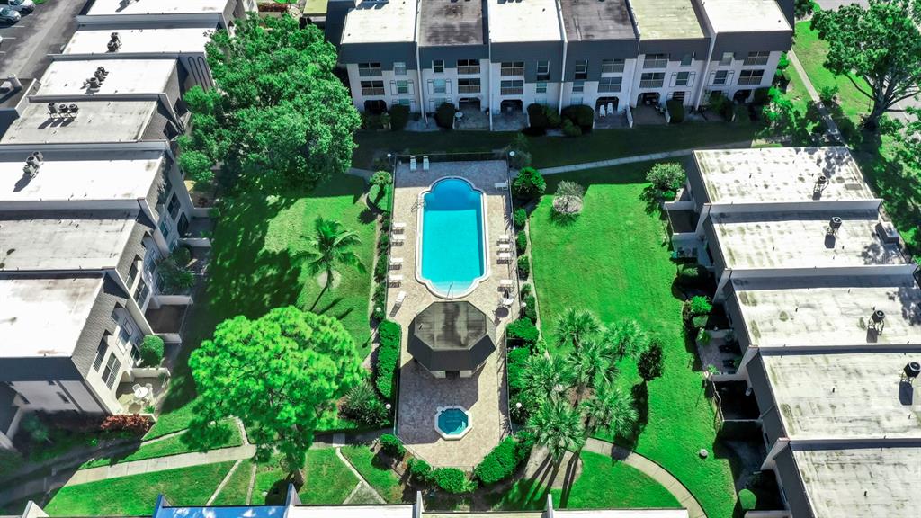 An aerial view shows a swimming pool and gazebo surrounded by apartment buildings and lawns — 8799 BARDMOOR BOULEVARD UNIT 205, SEMINOLE, FL