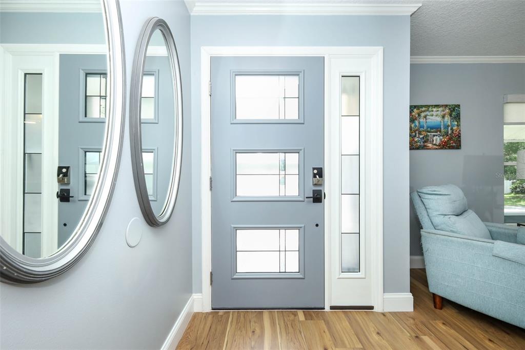 A light blue front door with three glass panels and a sidelight in an entryway — 1501 ELF STONE COURT, CASSELBERRY, FL