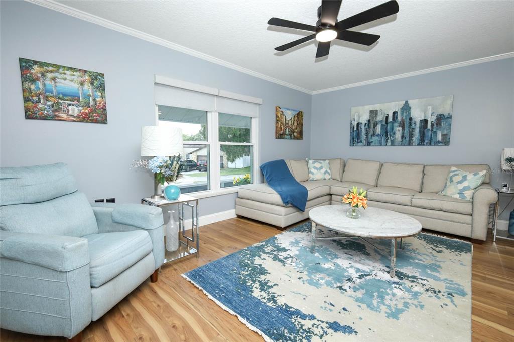 A living room features a light blue armchair, a sectional sofa, and a patterned area rug — 1501 ELF STONE COURT, CASSELBERRY, FL