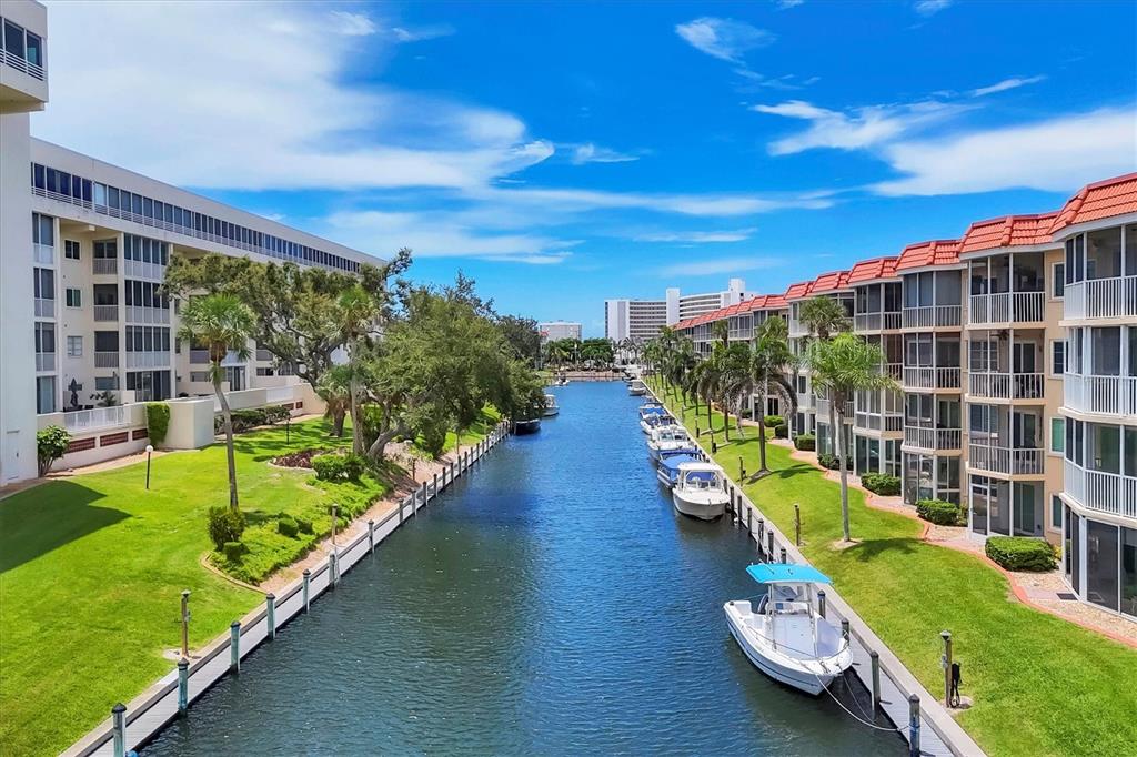 An aerial view of a white sand beach with turquoise water and scattered swimmers — 1350 N PORTOFINO DRIVE UNIT 107, SARASOTA, FL