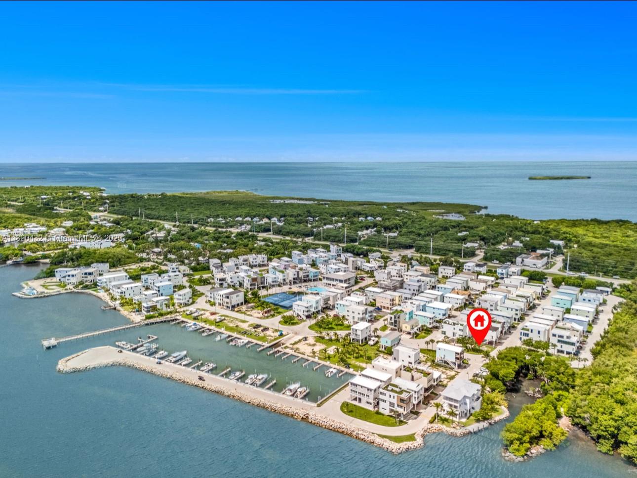 An aerial view shows a waterfront residential community with a marina and a marked house — 94825 Overseas Hwy, Key Largo FL 33037, KEY LARGO, FL