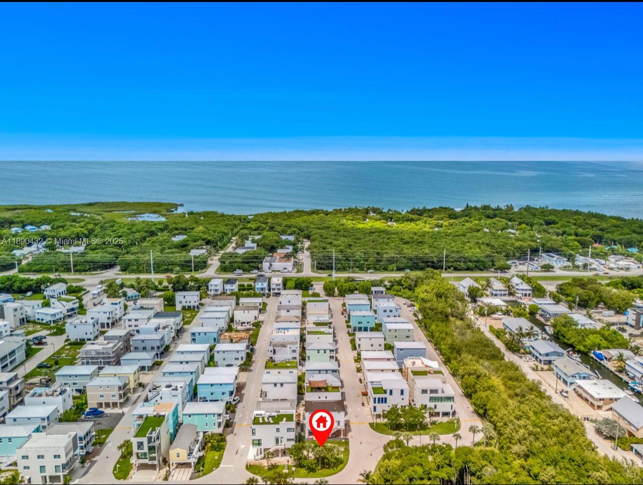 An aerial view shows a coastal neighborhood with a marked house near the water — 94825 Overseas Hwy, Key Largo FL 33037, KEY LARGO, FL