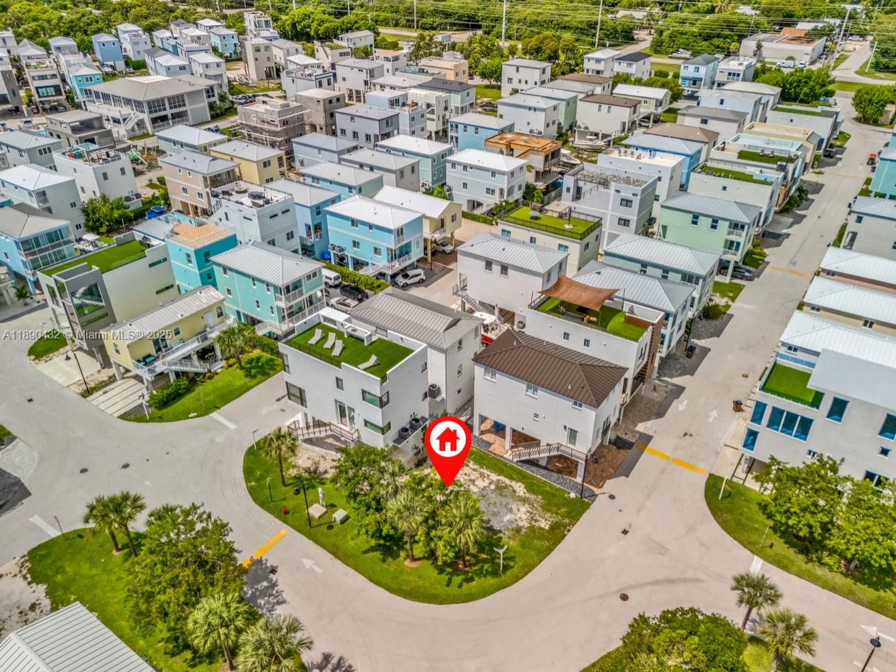An aerial view shows a modern residential neighborhood with houses featuring rooftop decks and terraces — 94825 Overseas Hwy, Key Largo FL 33037, KEY LARGO, FL