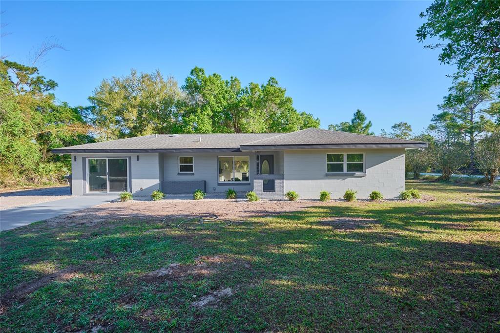 A single-story gray house with a flat roof sits on a grassy lot — 3500 ORCHID DRIVE, INDIAN LAKE ESTATES, FL