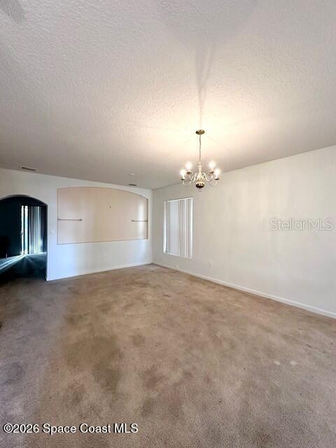 This room features beige carpeting, a chandelier, and a large arched wall niche — 782 MARIAN COURT, TITUSVILLE, FL
