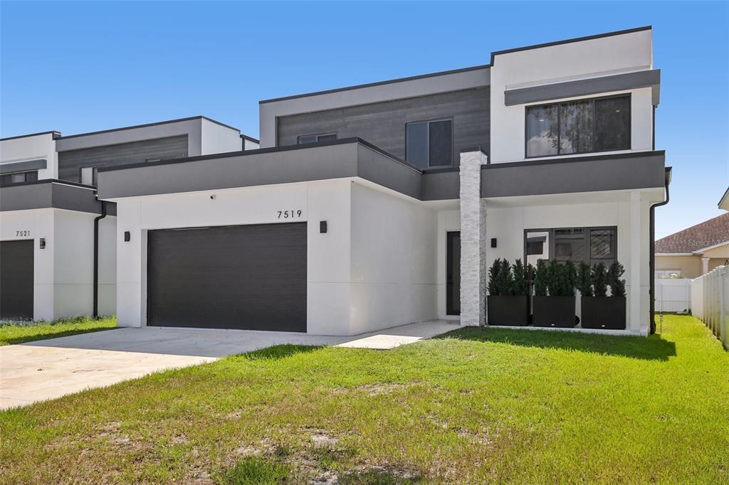 A modern two-story house with a white and gray exterior and a two-car garage — 7519 N COOLIDGE AVENUE, TAMPA, FL