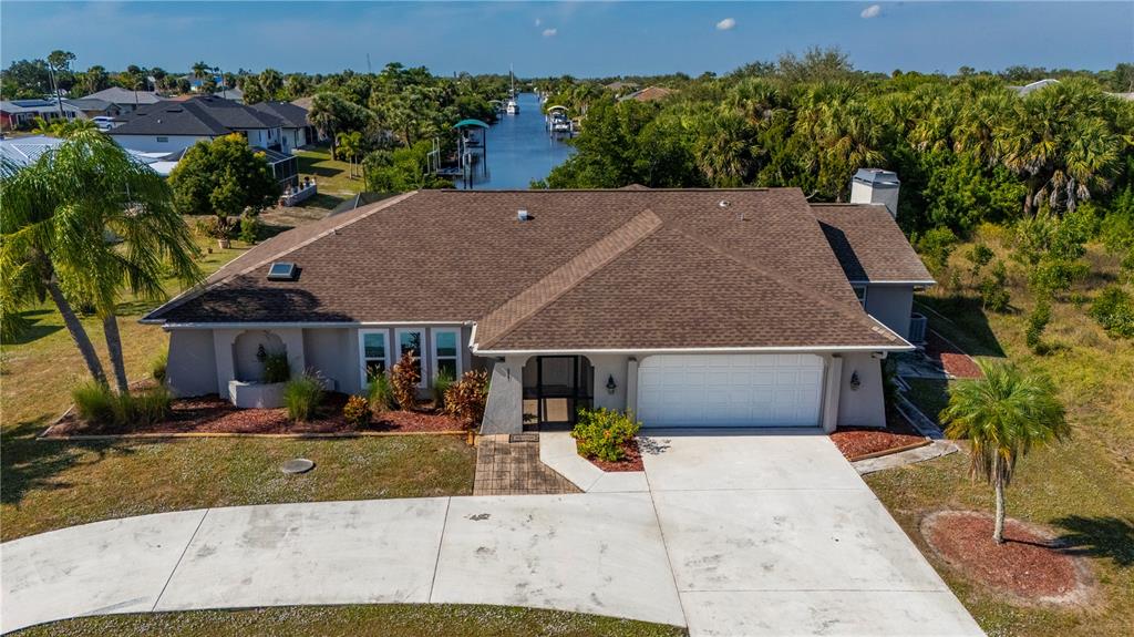 An aerial view of a single-story house with a brown roof and a concrete driveway — 5087 SILVER BELL DRIVE, PORT CHARLOTTE, FL