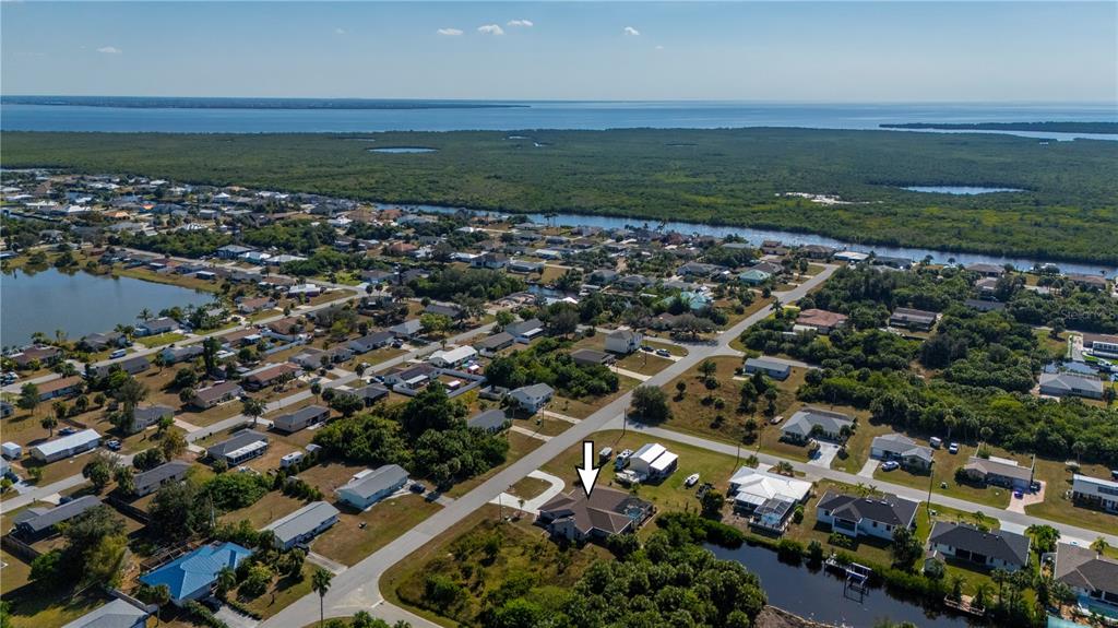 An aerial view shows a residential neighborhood with a house marked by a white arrow — 5087 SILVER BELL DRIVE, PORT CHARLOTTE, FL