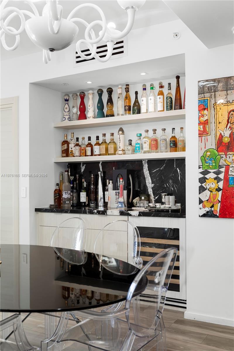 A home bar area features illuminated shelves, a black marble backsplash, and a wine cooler — 801 S Miami Ave # 3310, Miami FL 33130, MIAMI, FL