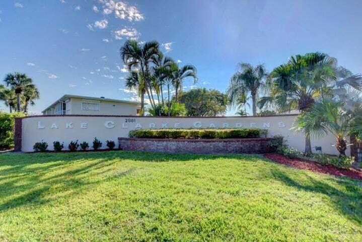 A curved beige wall with the name Lake Clarke Gardens stands behind a grassy lawn — 2566 GARDEN Drive S # 306, Lake Worth FL 33461, LAKE WORTH, FL