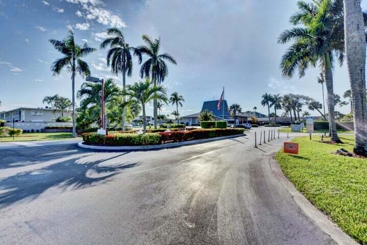 A paved driveway leads toward a building entrance surrounded by palm trees and landscaping — 2566 GARDEN Drive S # 306, Lake Worth FL 33461, LAKE WORTH, FL
