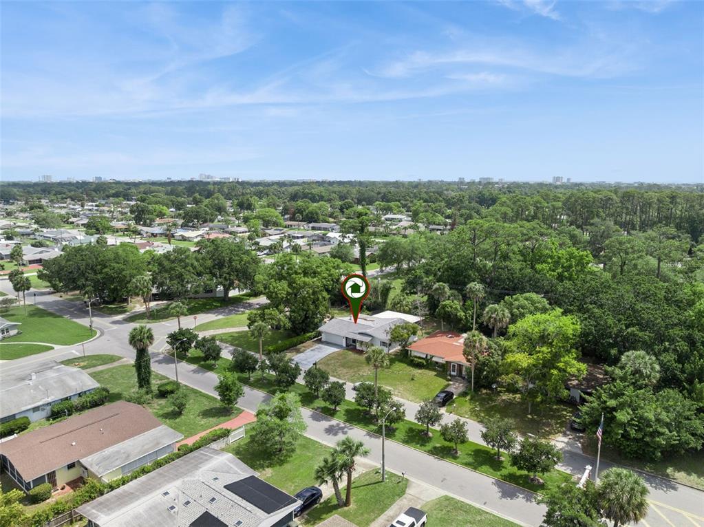 An aerial view shows a single-story house with a gray roof in a suburban neighborhood — 1507 MARGINA AVENUE, DAYTONA BEACH, FL