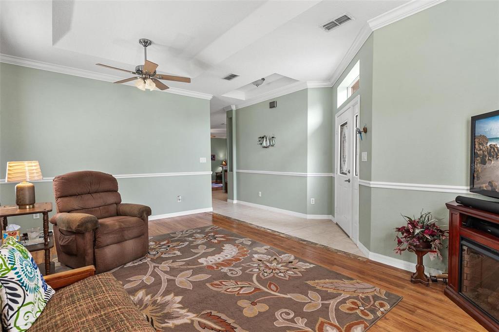 A living room with light green walls, a ceiling fan, and a brown recliner — 36403 GRAND ISLAND OAKS CIRCLE, GRAND ISLAND, FL