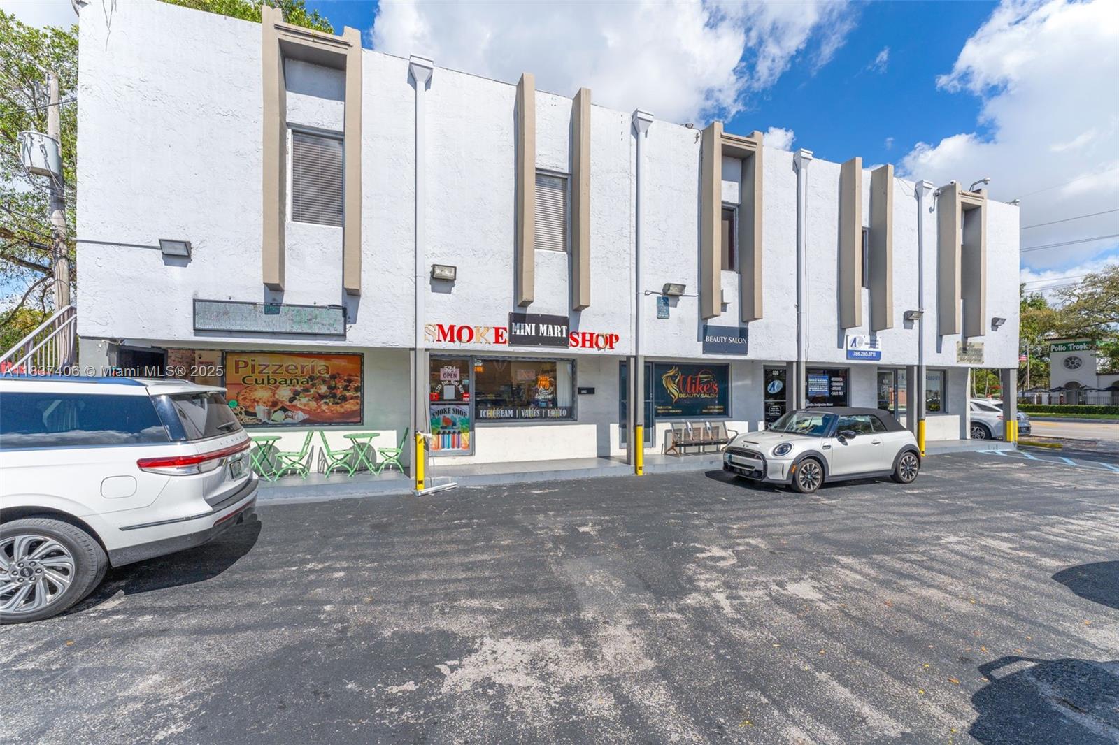A two-story commercial building with multiple storefronts and a parking lot in front — 516 NW 57th Ave, Miami FL 33126, MIAMI, FL