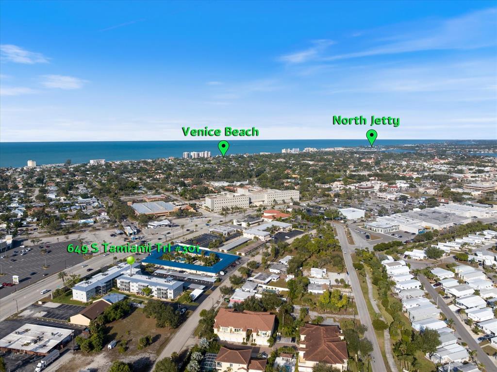 This is an aerial view of a coastal town featuring a highlighted residential building — 649 TAMIAMI TRAIL S UNIT 301, VENICE, FL