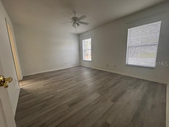 An empty bedroom features light gray wood-look flooring, white walls, and a ceiling fan — 1707 W BEACH PLUM DRIVE, CITRUS SPRINGS, FL