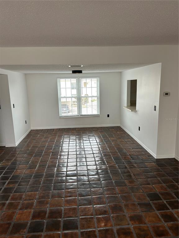 A dining room with dark, square floor tiles and a window overlooking the outdoors — 2462 KINGFISHER LANE UNIT J203, CLEARWATER, FL