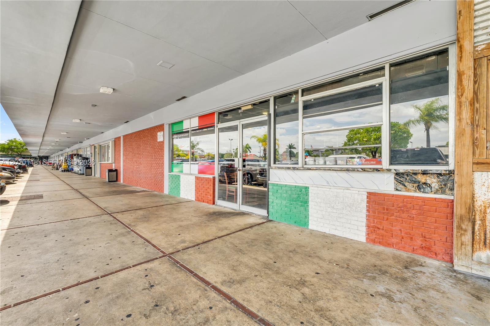 The exterior of a commercial storefront features brick walls painted in Italian flag colors — W 84 St, Hialeah FL 33014, HIALEAH, FL