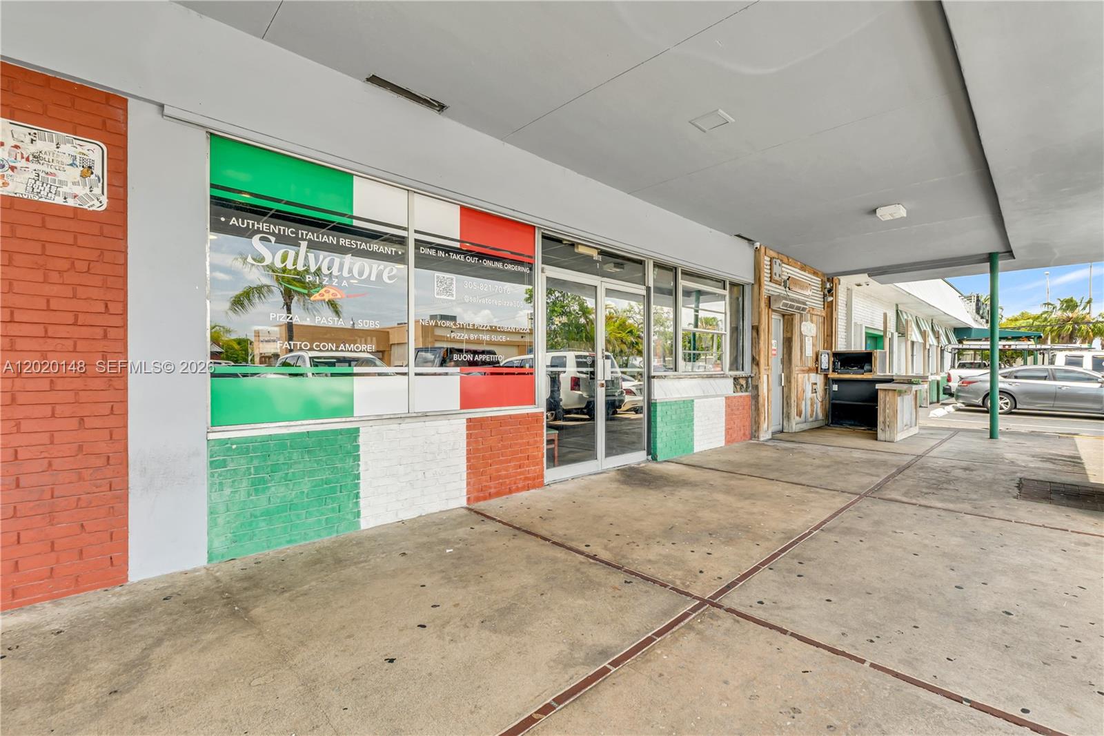 The exterior of a brick-fronted restaurant features Italian flag-themed window decals and a covered walkway — W 84 St, Hialeah FL 33014, HIALEAH, FL