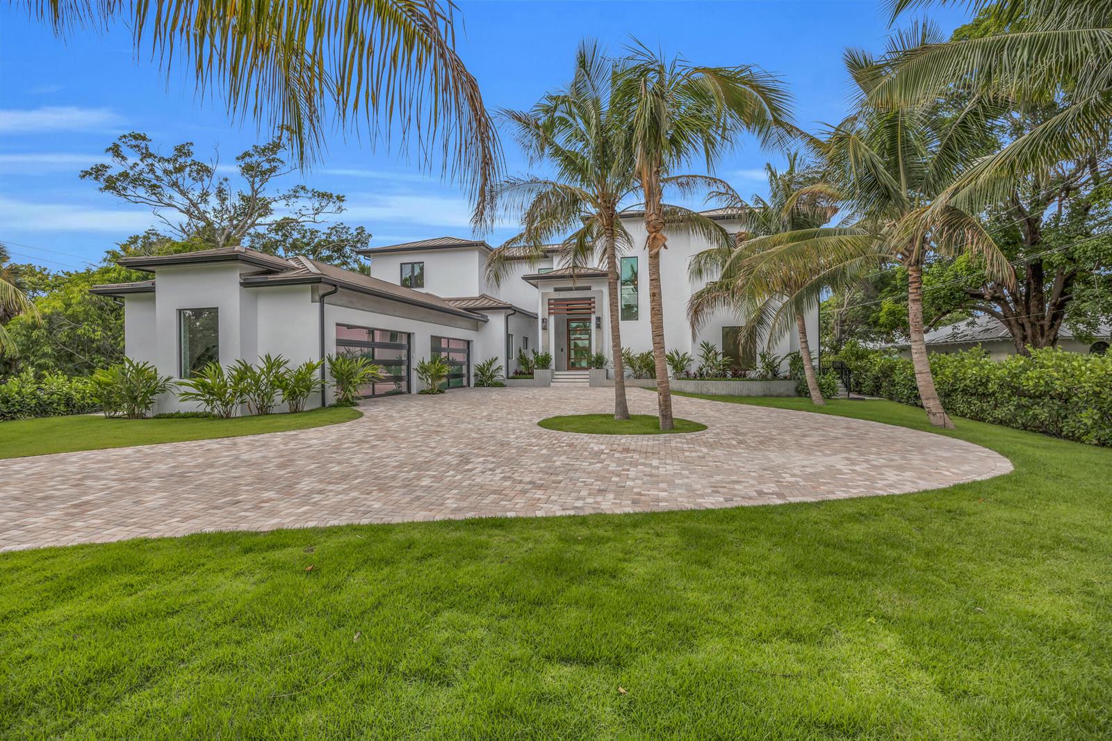 A modern white two-story house features a large circular paver driveway and palm trees — 19175 W Riverside Drive, Tequesta FL 33469, TEQUESTA, FL
