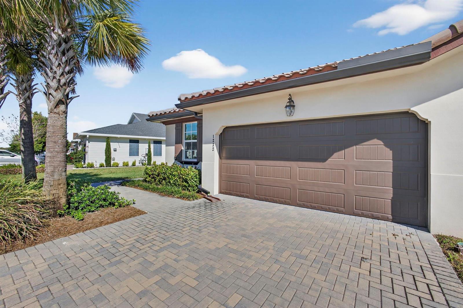 A paved driveway leads to a two-car garage on a house with a tile roof — 1232 Haywagon Trail # 0, Loxahatchee FL 33470, LOXAHATCHEE, FL