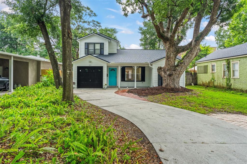 A two-story house with white siding, a black garage door, and a bright blue front door — 805 W SMITH STREET, ORLANDO, FL
