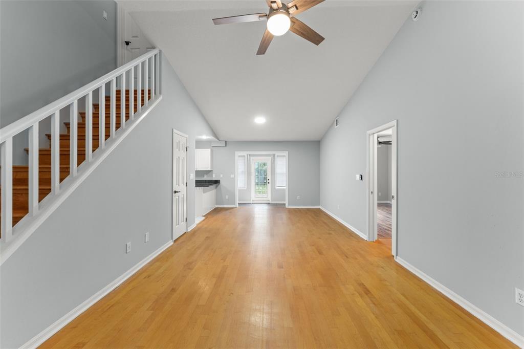 An interior view of a living room with hardwood floors, a staircase, and a ceiling fan — 805 W SMITH STREET, ORLANDO, FL