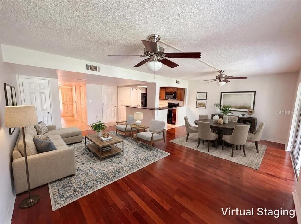 A living and dining room with hardwood floors, ceiling fans, and virtual staging furniture — 3538 DAIRY ROAD UNIT 0, TITUSVILLE, FL