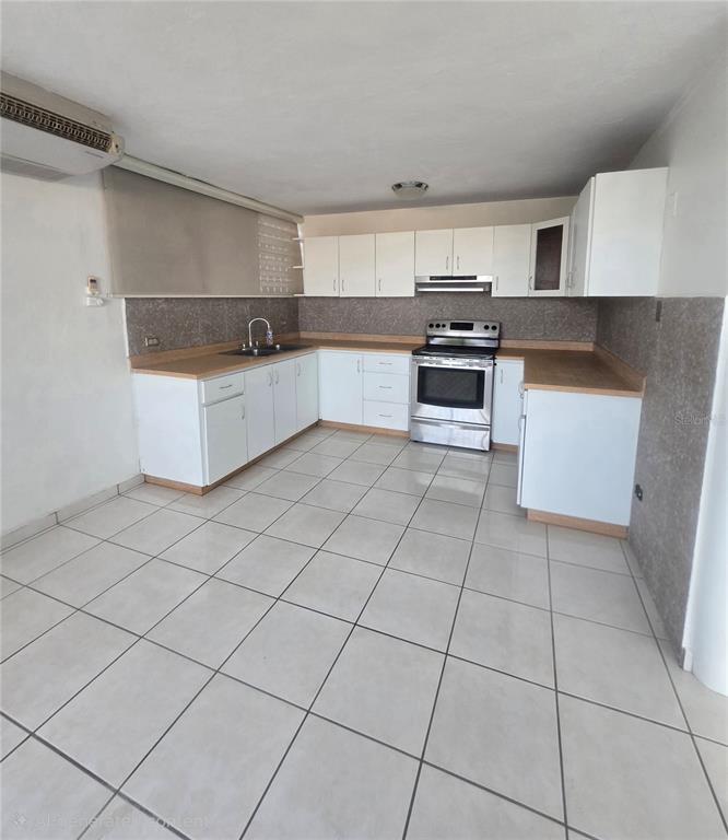 A kitchen features white cabinets, light countertops, stainless steel appliances, and light-colored floor tiles — 1608 TAMESIS apt. 201B, SAN JUAN, PR