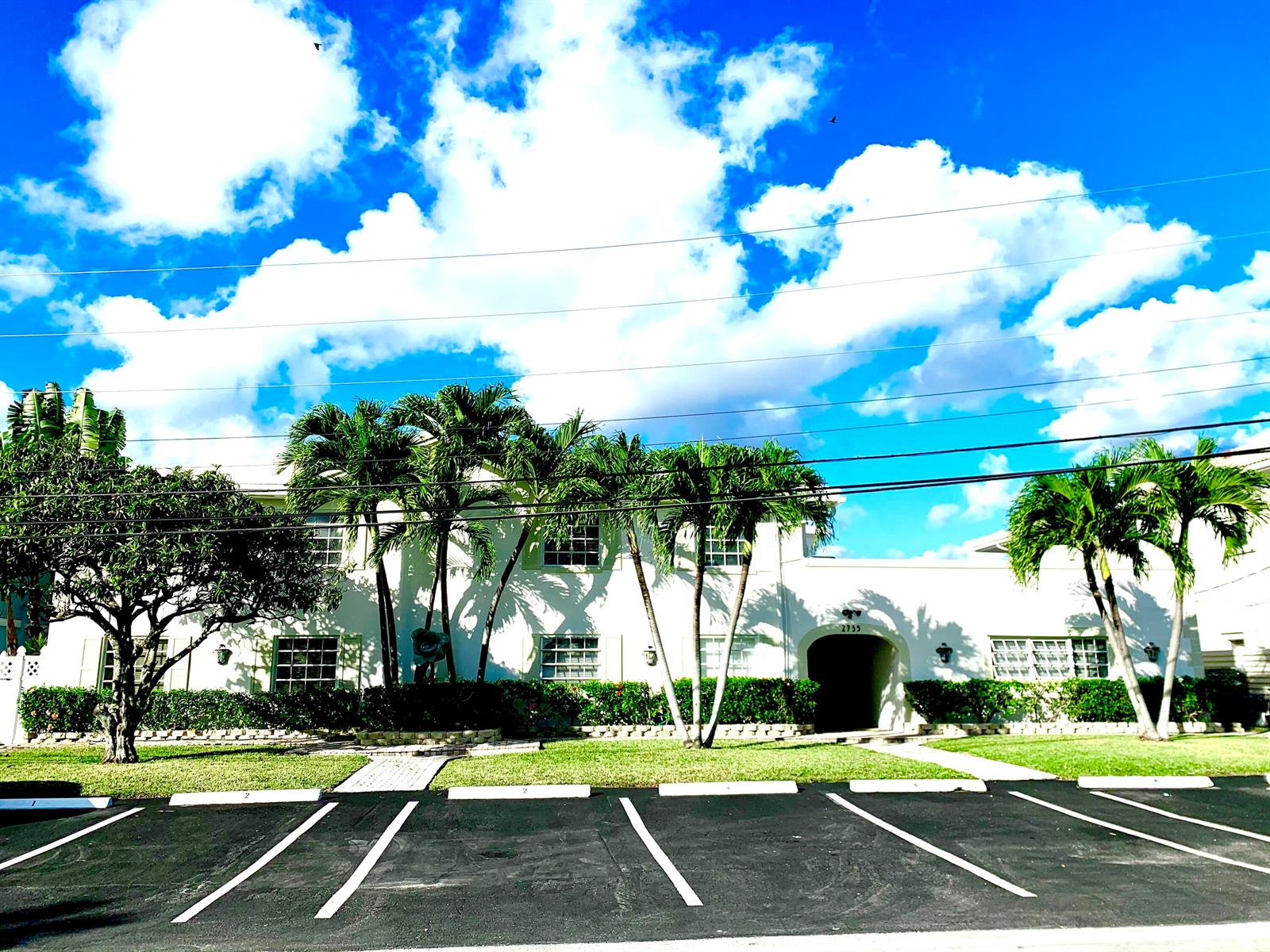 A two-story white apartment building with palm trees and a parking lot in front — 2735 NE 28 Court, Lighthouse Point FL 33064, LIGHTHOUSE POINT, FL