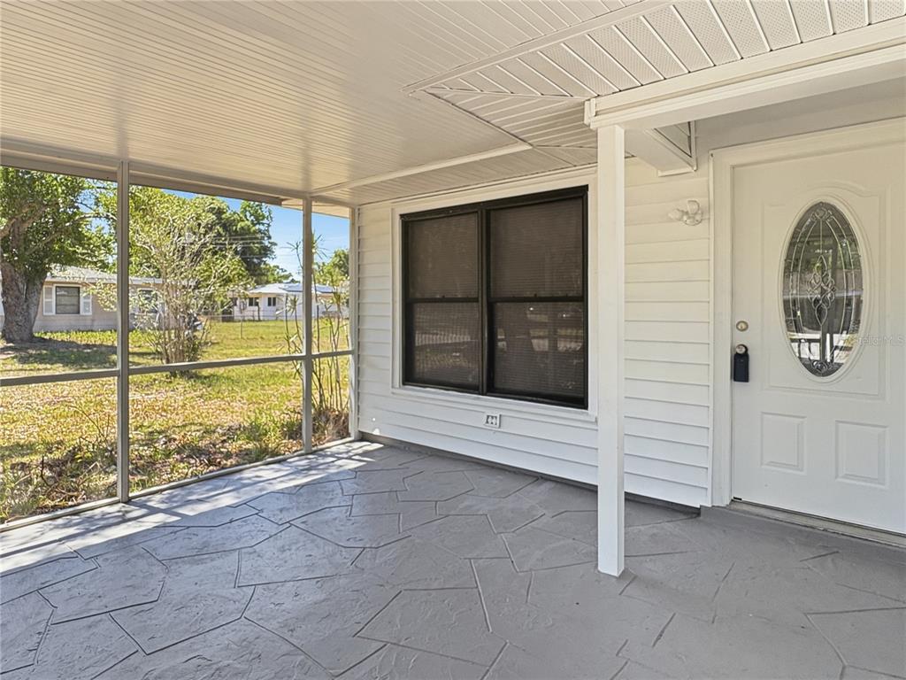 A bright, empty room features white walls, light-colored tile flooring, two windows, and a ceiling fan — 2847 OAK STREET, SARASOTA, FL