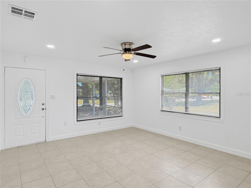A bright room with white walls, tile flooring, a ceiling fan, and an arched doorway — 2847 OAK STREET, SARASOTA, FL