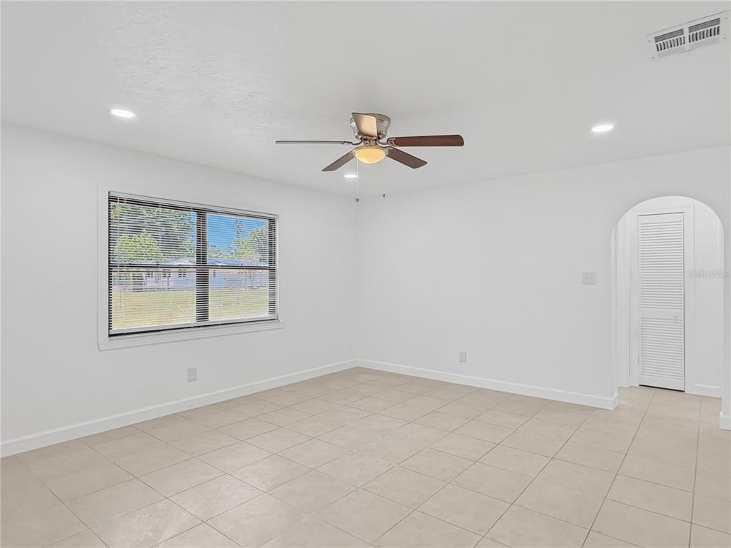A kitchen features white cabinets, stainless steel appliances, tan tile backsplash, and light floor tiles — 2847 OAK STREET, SARASOTA, FL