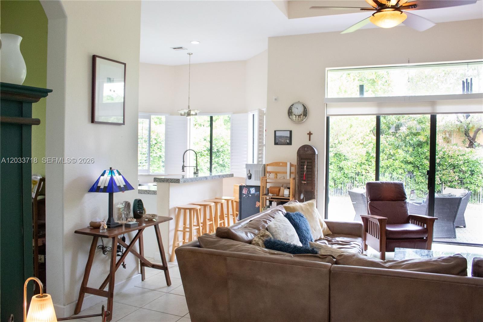 A living room with a brown leather sofa, an armchair, and an open kitchen area — 7645 SW 193rd Ln, Cutler Bay FL 33157, CUTLER BAY, FL