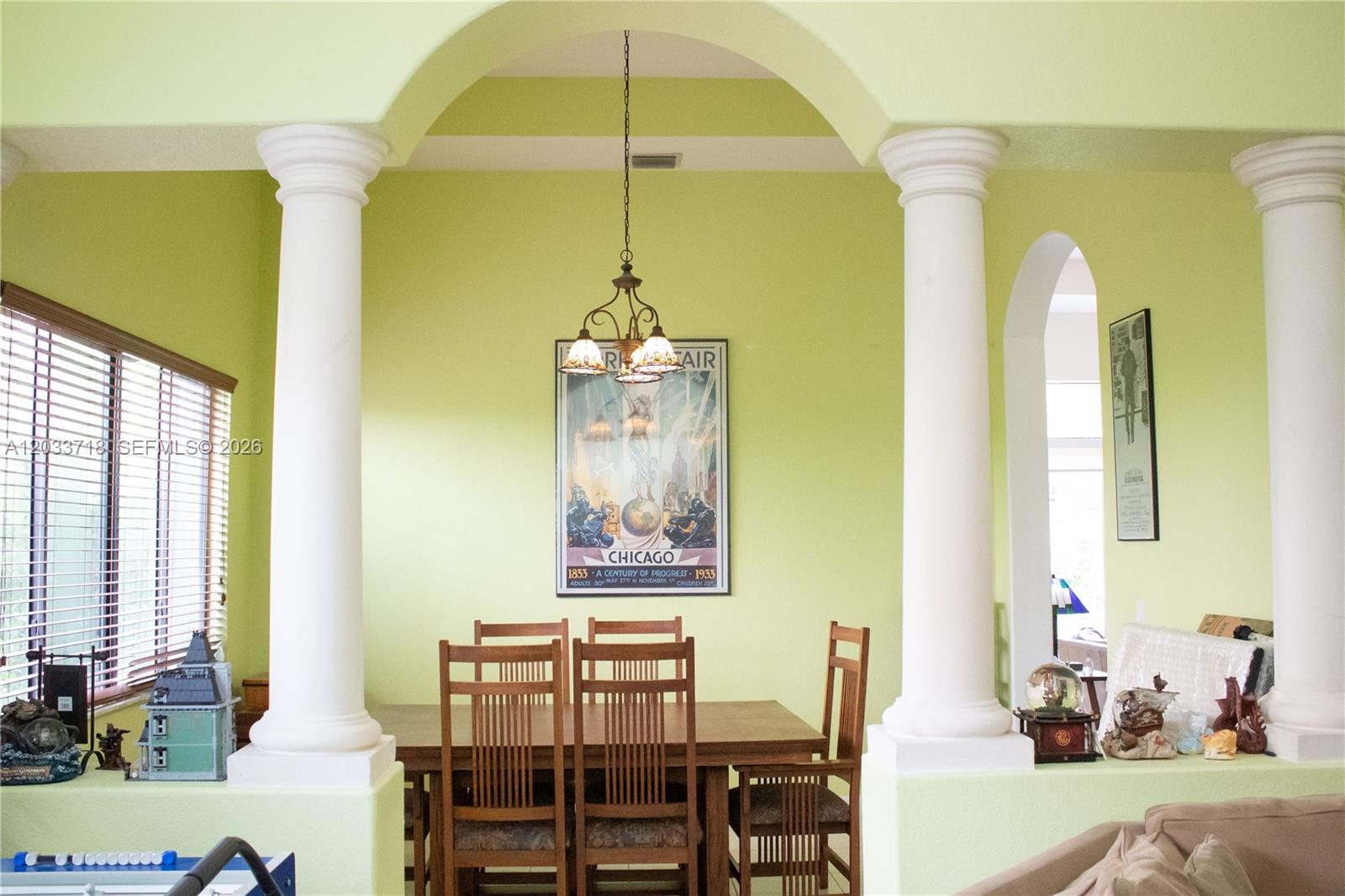 A dining area features a wooden table, chairs, and a vintage poster under an arched ceiling — 7645 SW 193rd Ln, Cutler Bay FL 33157, CUTLER BAY, FL