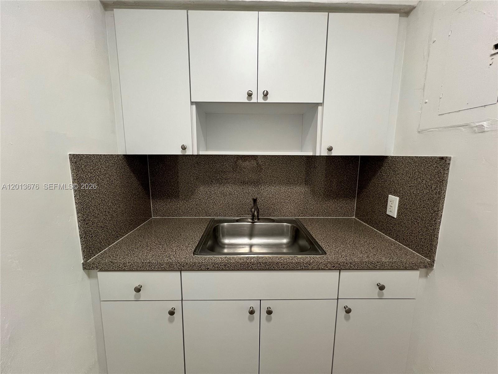 A small kitchen area features white cabinets, a stainless steel sink, and speckled countertops — 5600 NE 1st Ave # 2, Miami FL 33137, MIAMI, FL