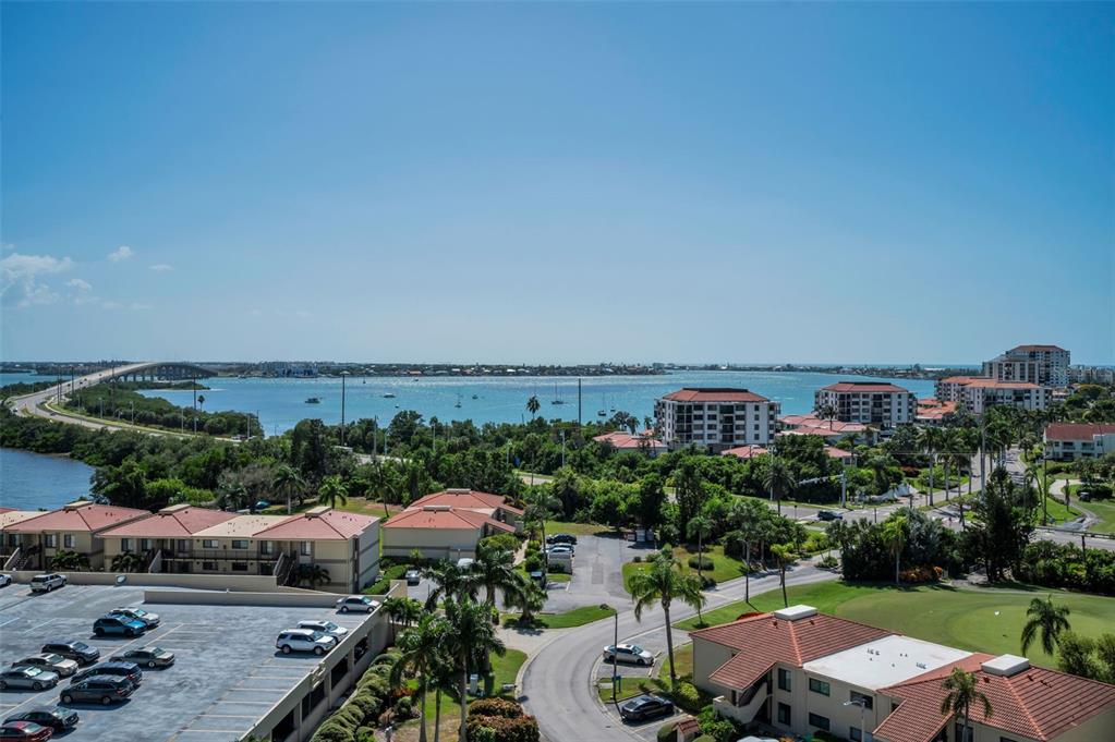 An elevated view shows a coastal landscape with buildings, a parking lot, and a bridge — 6322 PALMA DEL MAR BOULEVARD S UNIT 1104, ST PETERSBURG, FL