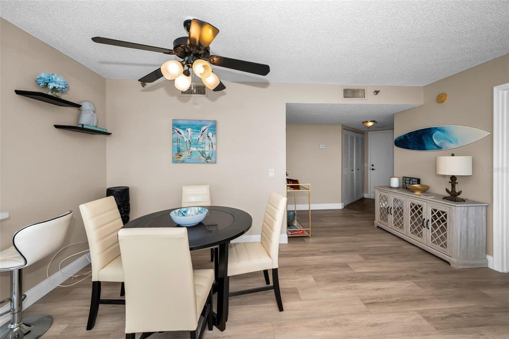 A dining area features a round table, four chairs, a ceiling fan, and a sideboard — 6322 PALMA DEL MAR BOULEVARD S UNIT 1104, ST PETERSBURG, FL