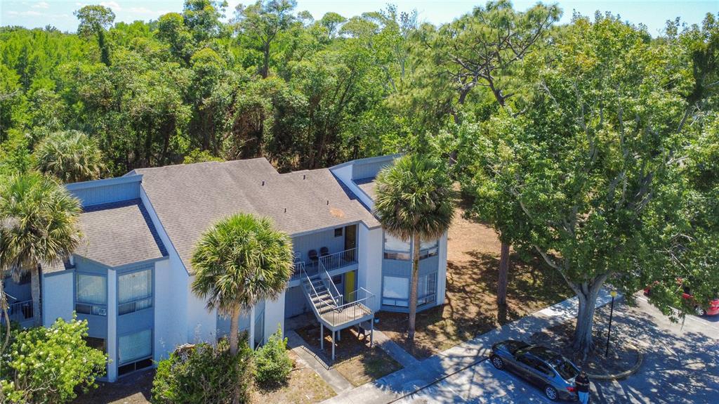 An aerial view of a two-story apartment building surrounded by trees and a parking lot — 2636 LEMON TREE LANE, ORLANDO, FL