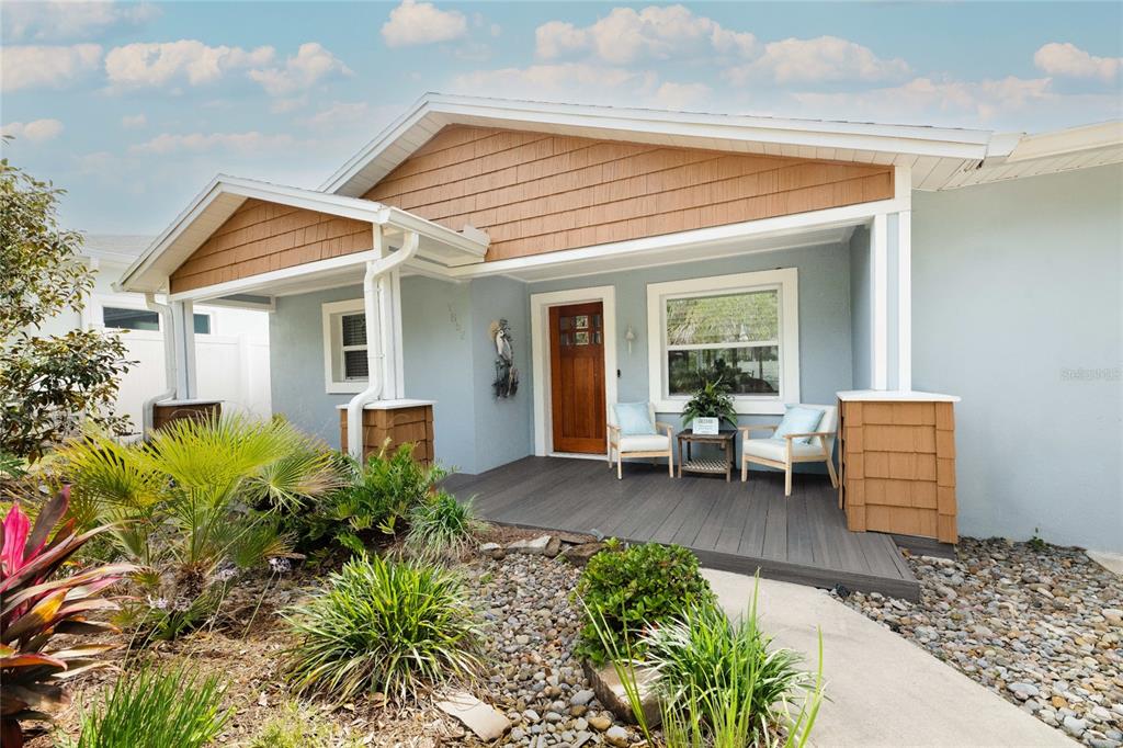 A light blue house features a brown shingled gable, a wooden front door, and a deck — 1852 S FLAGLER AVENUE, FLAGLER BEACH, FL