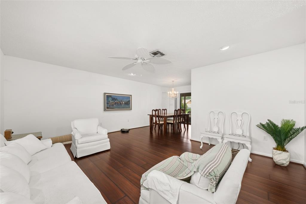 A living and dining area with white furniture, dark wood floors, and a ceiling fan — 4524 HARDER AVENUE, SEBRING, FL