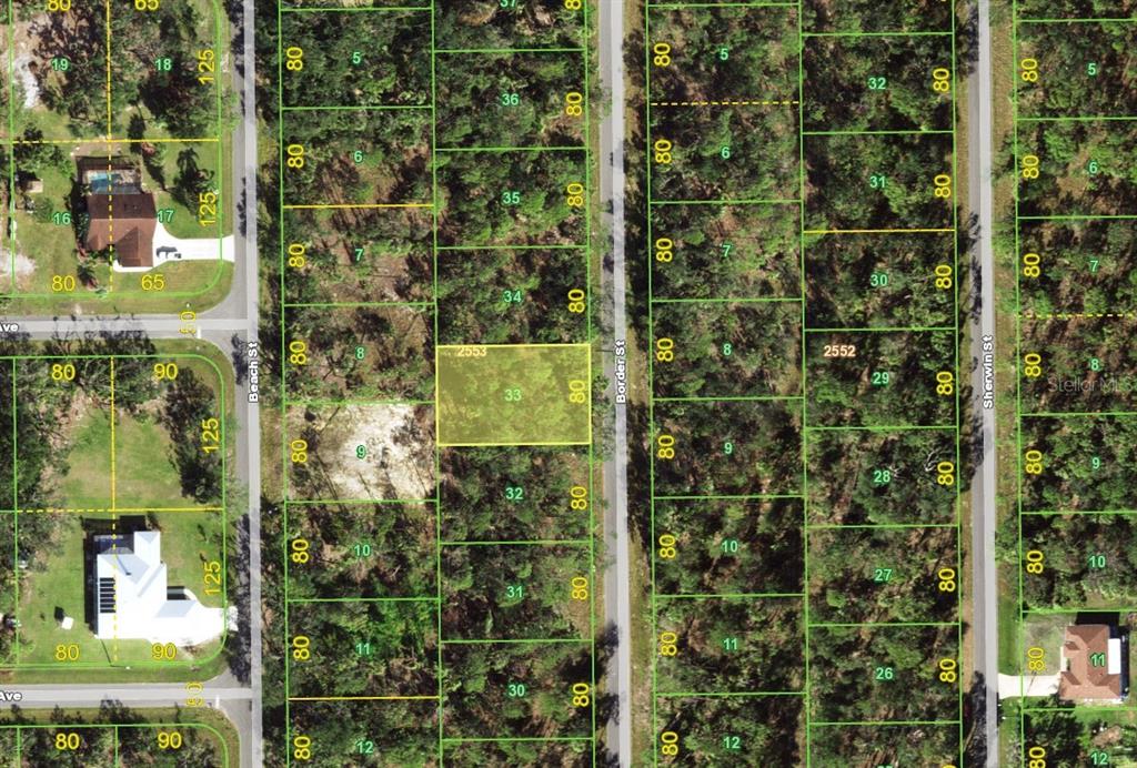 This is an aerial map showing a highlighted vacant lot surrounded by wooded residential parcels — 1069 BORDER STREET, PORT CHARLOTTE, FL
