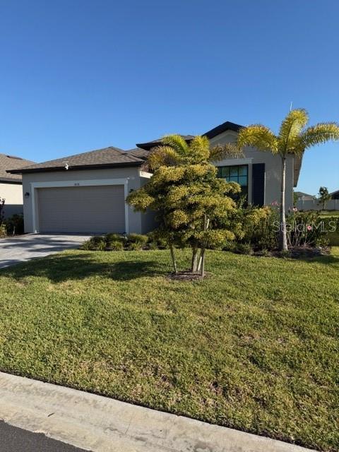 A single-story house with a two-car garage and a palm tree in the front yard — 1638 SADDLEWOOD CIRCLE, PORT CHARLOTTE, FL