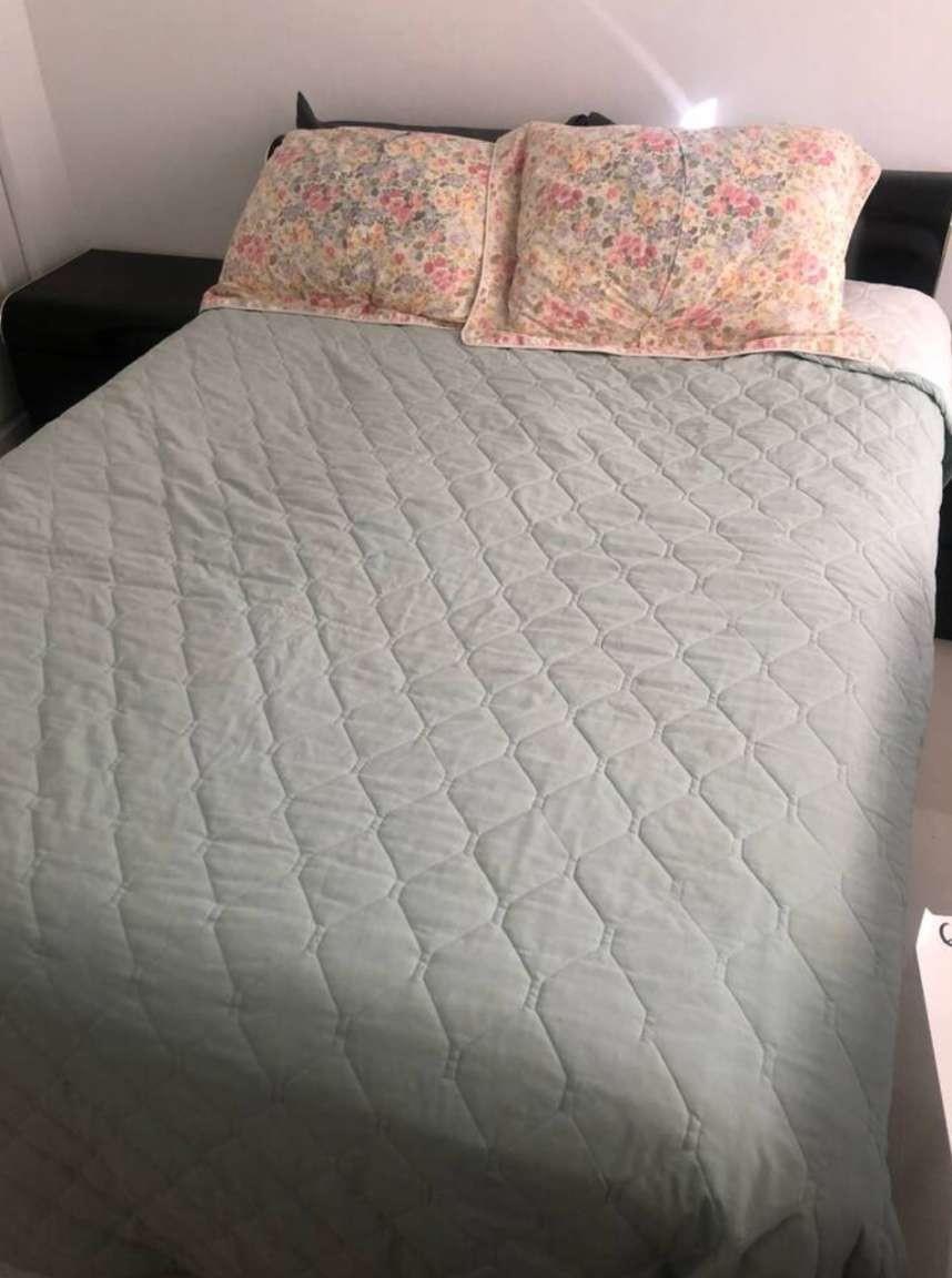 A bed with a light green quilted cover and two floral pillows in a bedroom — 862 Vista Meadows Drive, Weston FL 33327, WESTON, FL