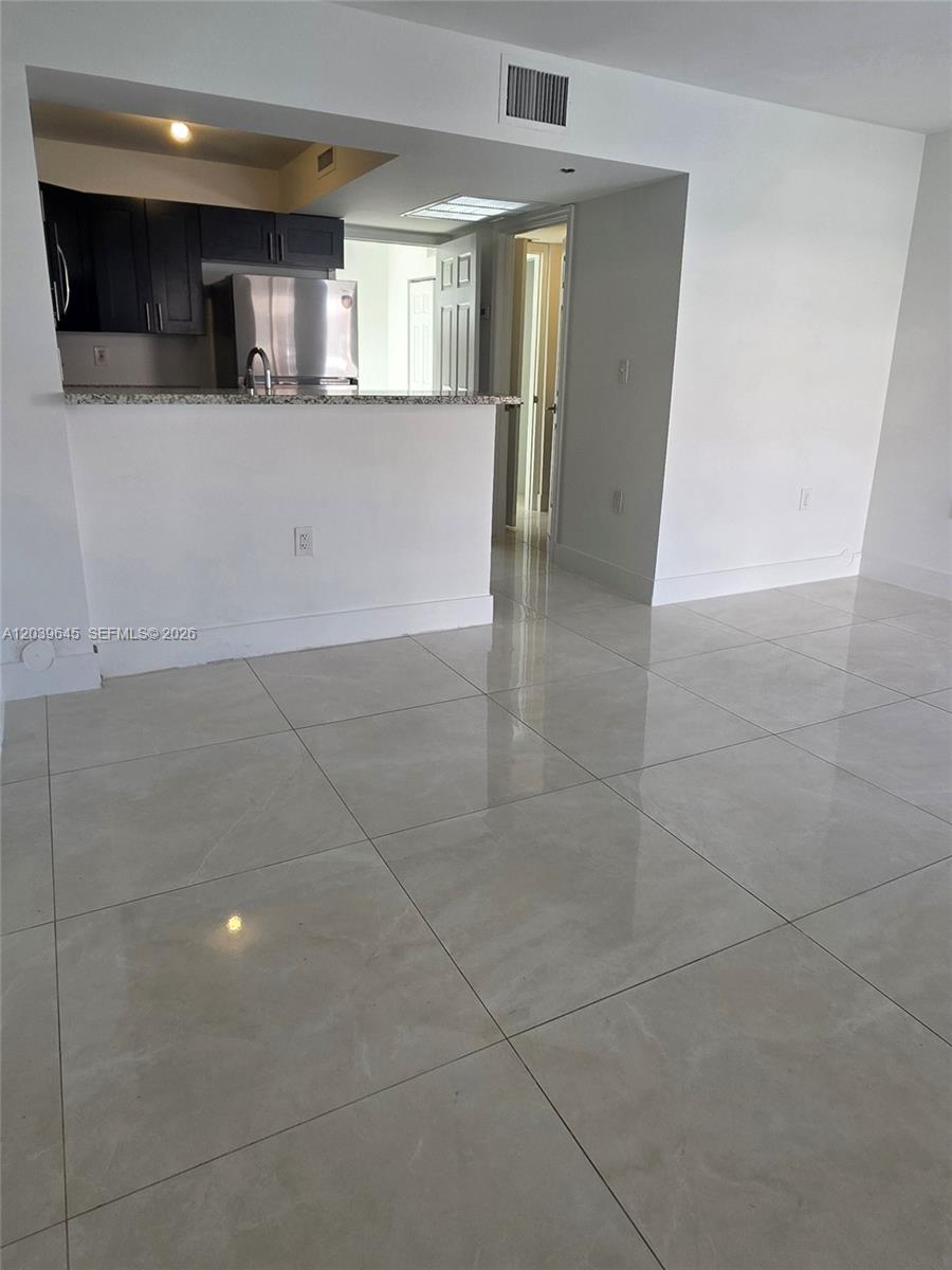 A tiled living area features a kitchen pass-through with dark cabinets and stainless steel appliances — 2154 W 60th St # 12111, Hialeah FL 33016, HIALEAH, FL