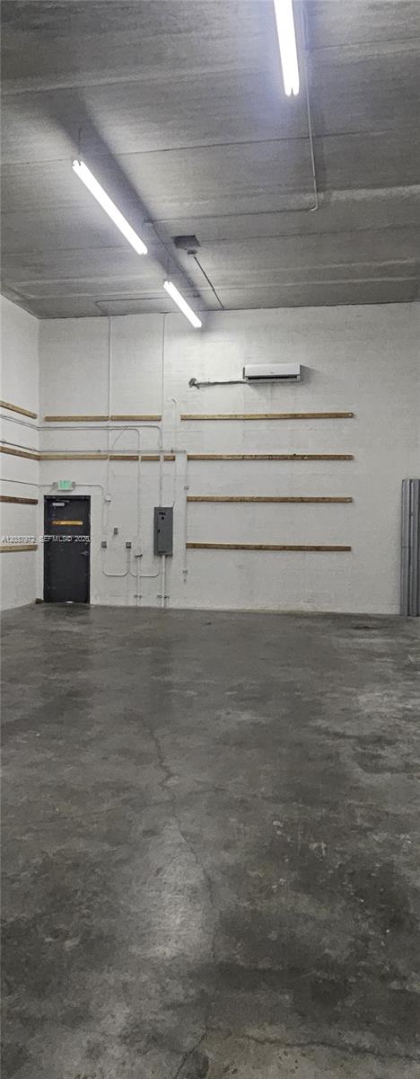 An empty industrial warehouse space features concrete floors, white walls, and exposed ceiling lighting — 15075 SW 137th St # 14, Miami FL 33196, MIAMI, FL