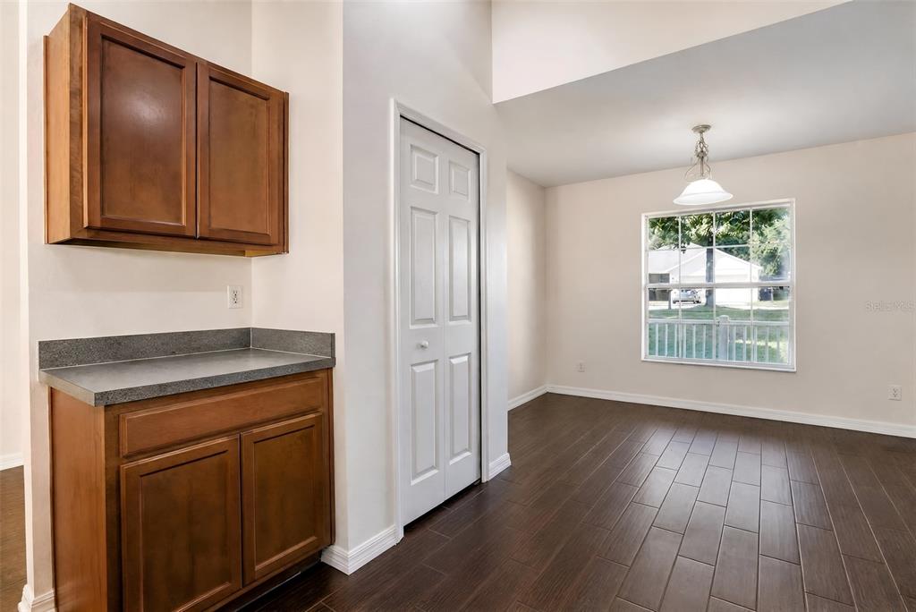 A dining area with dark wood-look tile flooring, a window, and a small built-in cabinet — 2079 NEWTOWN ROAD, GROVELAND, FL