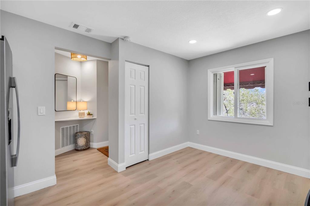 A room with light wood flooring, gray walls, a white door, and a window — 6101 34TH STREET W UNIT 1D, BRADENTON, FL